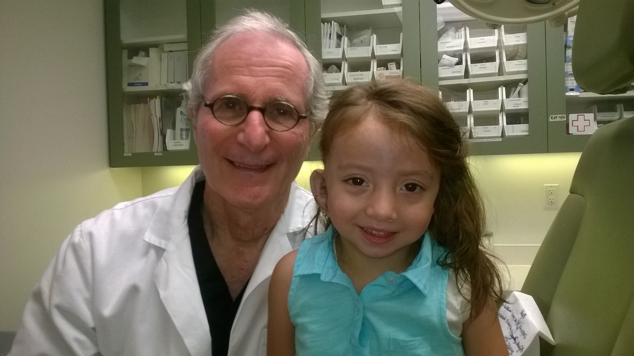 Belén con su doctor durante la primera cirugía de reconstrucción de orejas.
